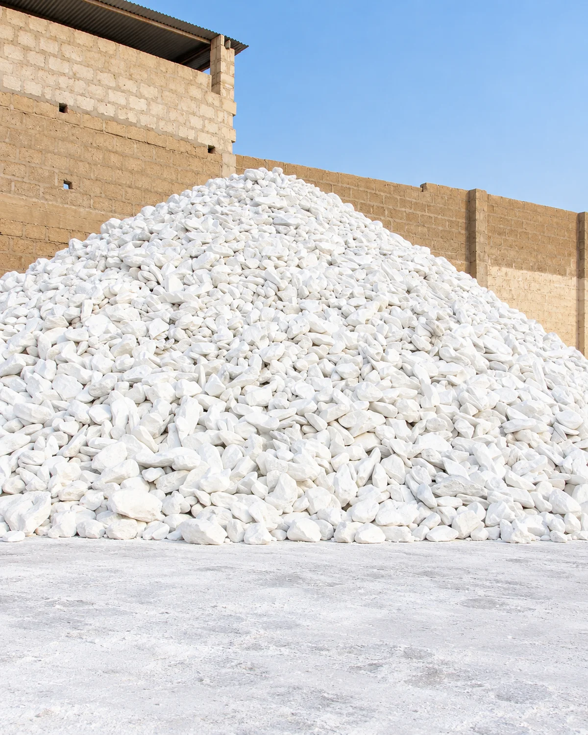 Afghan talc stockpile beside a masonry yard wall