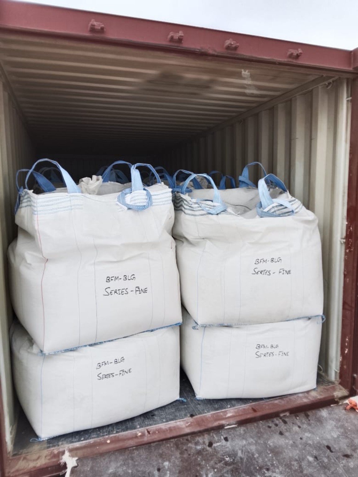 Jumbo bags of mineral material stacked inside a shipping container