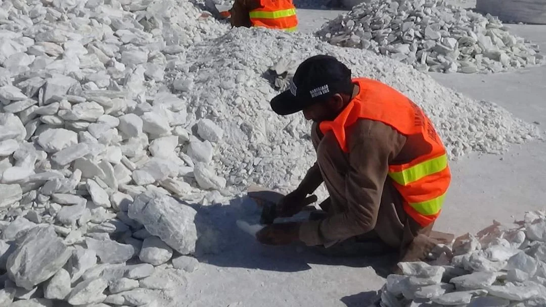 Worker preparing an individual talc lump by hand